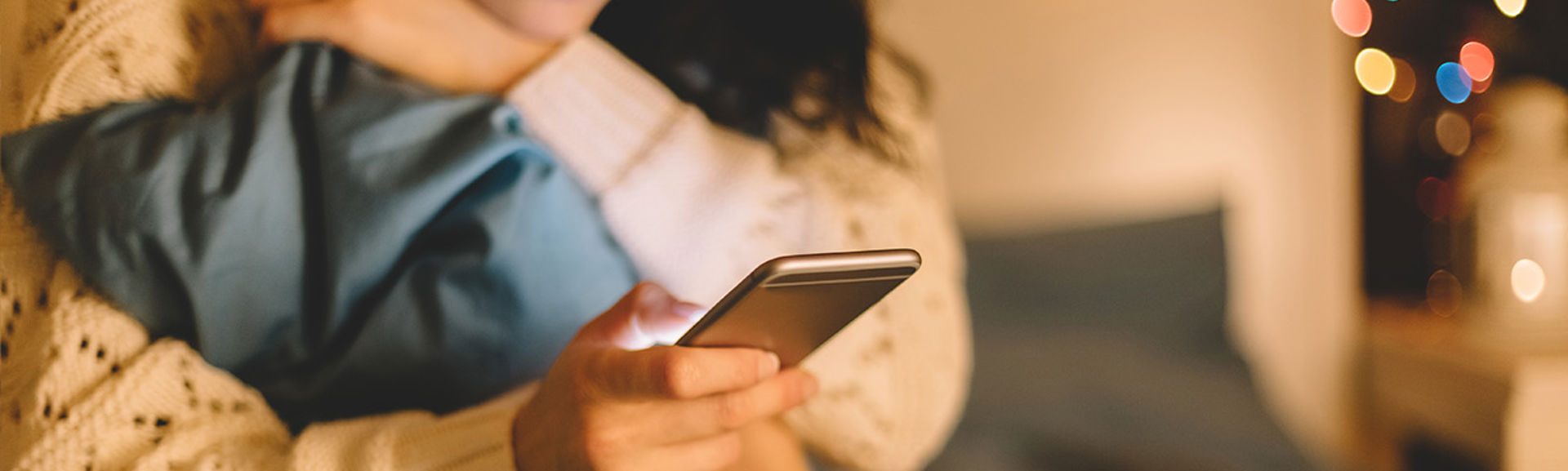 Close up of a girl on a bed using a mobile phone