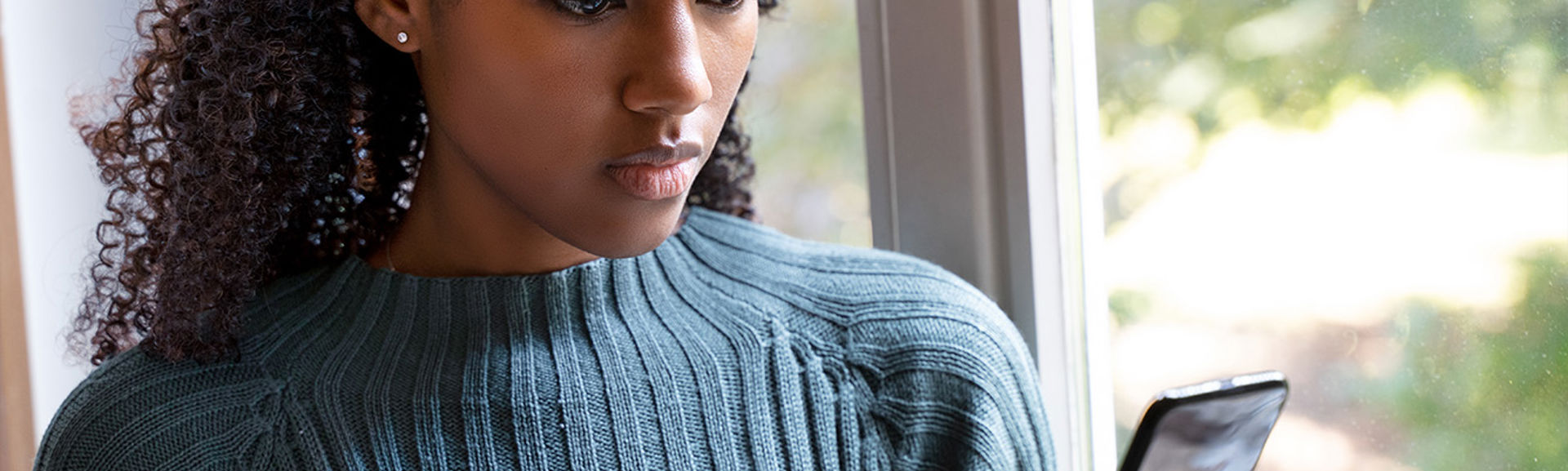 Woman in blue jumper looking at mobile phone